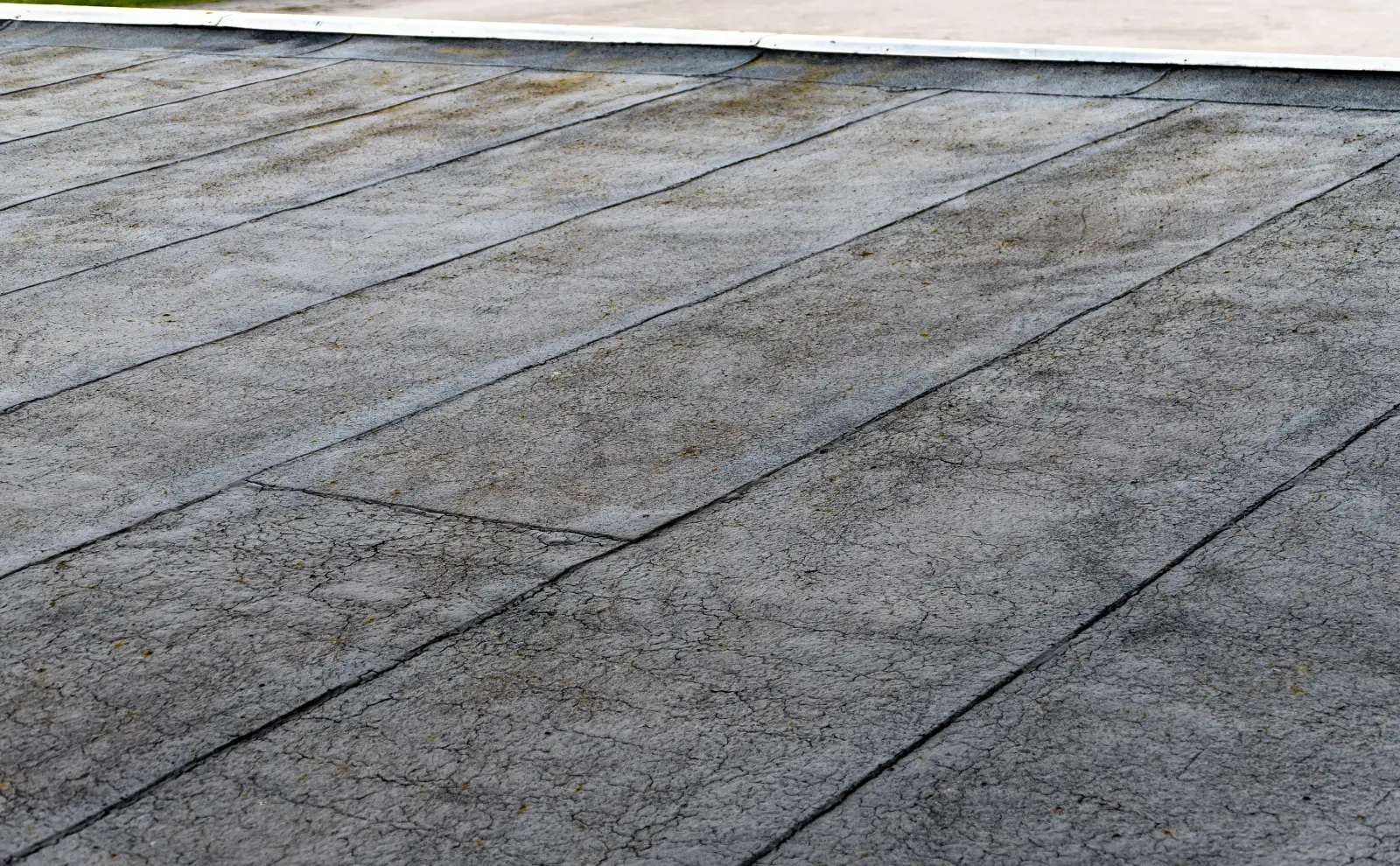 Aged, cracked bituminous membrane on a flat roof, ready for a restoration coating